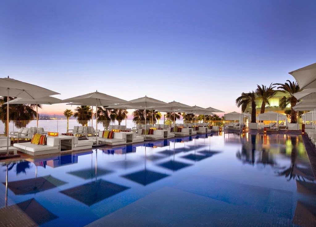 Palm trees and umbrellas line the posh pool at the W Barcelona, a luxury hotel at the end of Barceloneta.