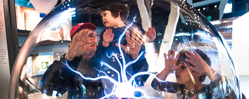 Barcelona Sightseeing,CosmoCaixa: a family interacting with one of the interactive displays at CosmoCaixa, Barcelona's sience museum.